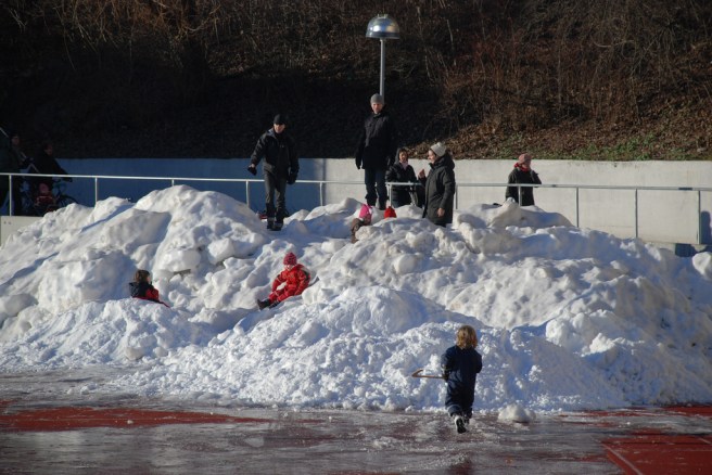 Kids play in piles of snow