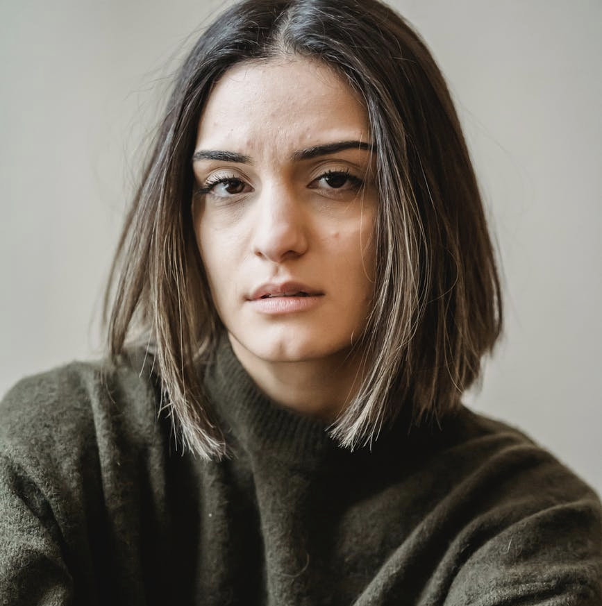 thoughtful young ethnic woman looking at camera
