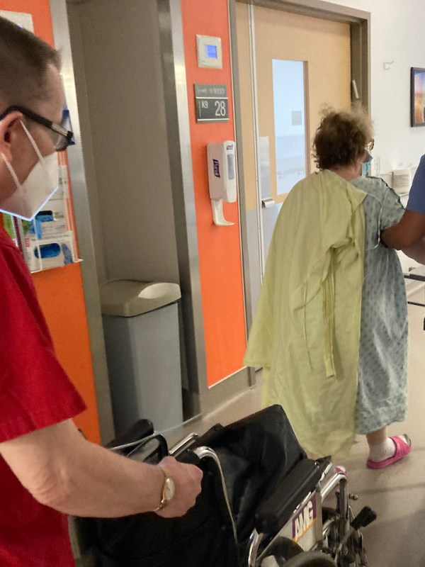 Ellie walking with nurse and John behind them